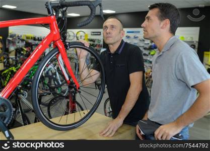 salesman in bicycle shop selling to a client