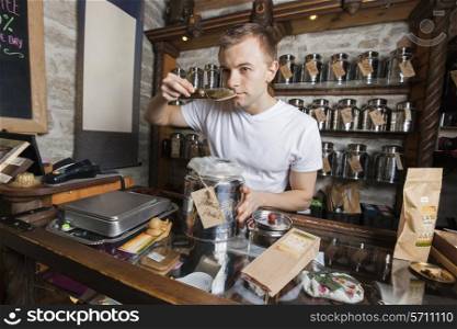 Salesman smelling tea in store