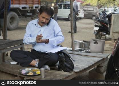 Salesman talking on a mobile phone and writing on paper