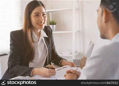 Salesmen are letting the male customers sign the sales contract, Asian women and men are doing business in the office, Business concept and contract signing