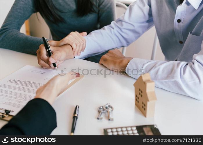 Salesmen are letting the male customers sign the sales contract house, Asian women and couple are doing business in the office, Business concept and contract signing