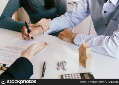 Salesmen are letting the male customers sign the sales contract house, Asian women and couple are doing business in the office, Business concept and contract signing