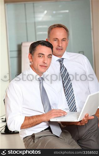 Salesmen meeting in the office with laptop