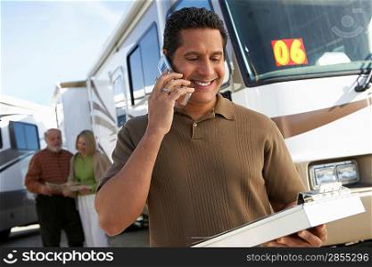 Salesperson on Cell Phone while Couple Shops for an RV