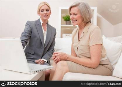 Saleswoman Advising a Senior Woman on Laptop Computer