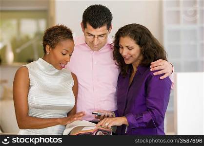 Saleswoman and Couple Examining Fabric Swatches