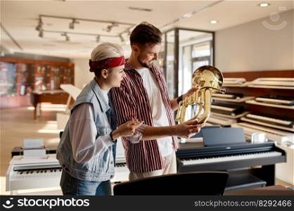 Saleswoman and male customer dialog about trumpet at music shop store. Female seller giving client advice how to choose instrument. Saleswoman and male customer dialog about trumpet at music instrument store
