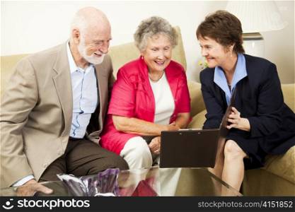 Saleswoman meets with senior couple in their home. Could be real estate, life insurance, etc.
