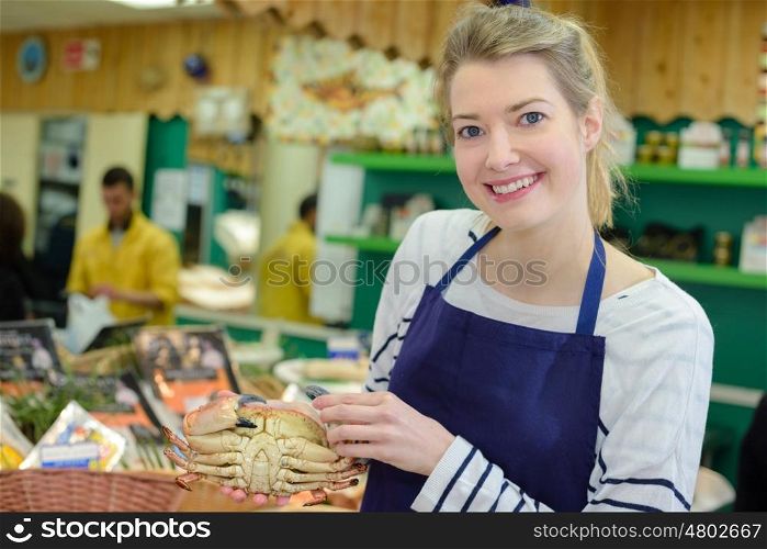 saleswoman offers fresh fish in a shop