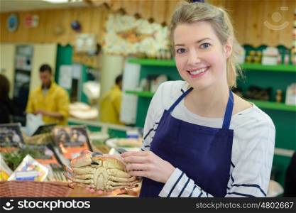 saleswoman offers fresh fish in a shop
