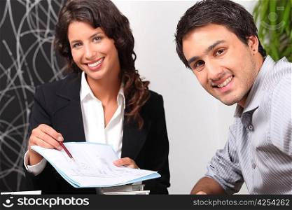 Saleswoman showing client where to sign