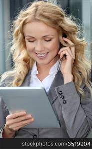Saleswoman using mobile phone and digital tablet