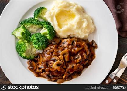 Salisbury steak with steamed broccoli and mashed potato