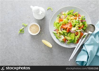 Salmon avocado salad with salted fish, fresh lettuce and red onion