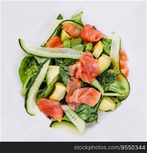 Salmon avocado salad with salted fish, lettuce, broccoli and cucumbers