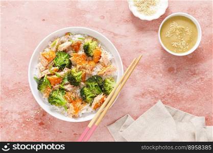 Salmon broccoli rice bowl with sesame sauce. Healthy diet food. Top view