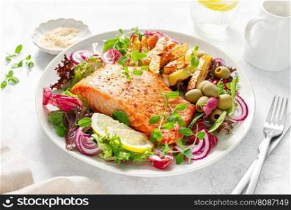 Salmon fillet grilled, fried potato and fresh vegetable green salad