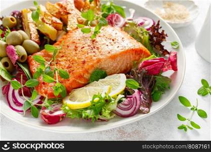 Salmon fillet grilled, fried potato and fresh vegetable green salad
