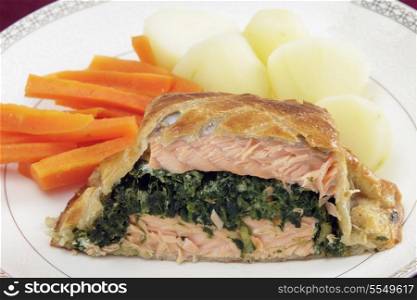 Salmon fillet stuffed with a spinach mixture and encased in puff pastry, served with boiled new potatoes and julienned carrots.