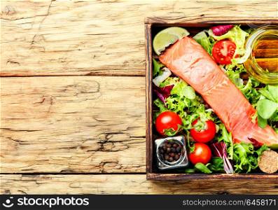 Salmon fillet with aromatic herbs. Salmon with spices and greens in wooden tray.Healthy eating