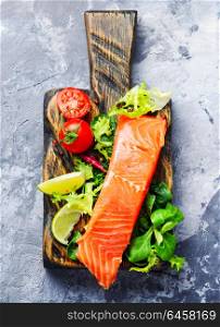 Salmon fillet with aromatic herbs. Salmon with spices and greens on the cutting board.Healthy eating