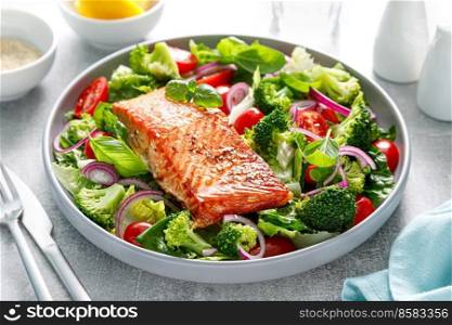 Salmon fish fillet grilled and fresh tomato salad with red onion and broccoli. Healthy food, diet. Ketogenic lunch
