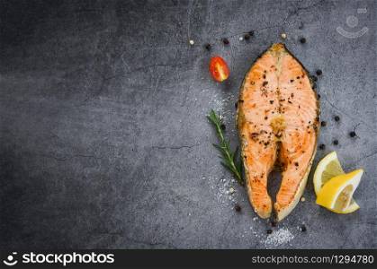 Salmon fish fillet steak seafood / Grilled salmon steak with herbs and spices rosemary lemon on dark background , top view copy space