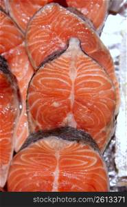 Salmon fish vivid slices in a row, marketplace textures
