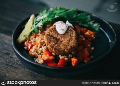 salmon fishcakes with oat and salad on wooden table