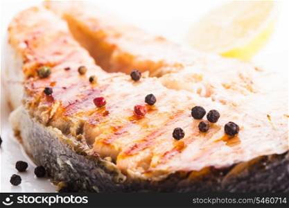 Salmon grilled steak with peppercorn and lemon close up