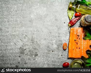 Salmon raw fillet with tomatoes, olive oil and spices. On a stone background.. Salmon fillet with tomatoes, olive oil and spices.