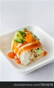 Salmon roll sushi. Salmon roll sushi with shrimp egg on top in white dish