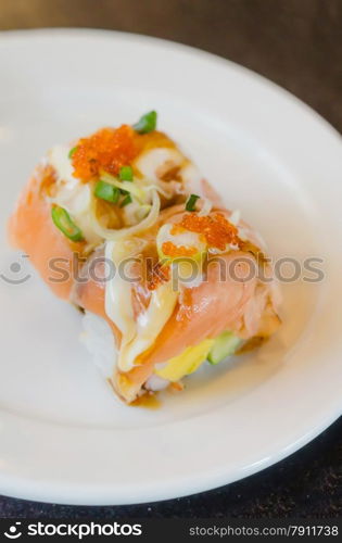 Salmon roll sushi. Salmon roll sushi with shrimp egg on top in white dish