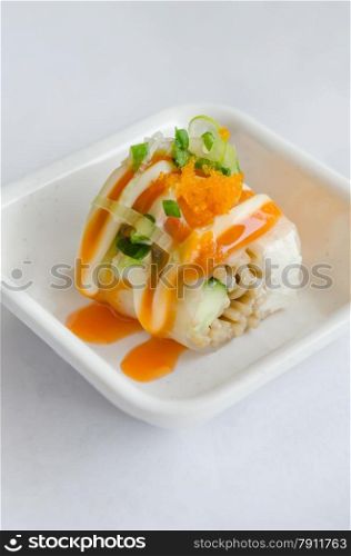 Salmon roll sushi. Salmon roll sushi with shrimp egg on top in white dish