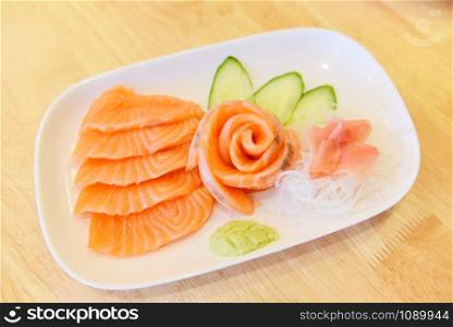Salmon sashimi menu set Japanese cuisine fresh ingredients on plate / Japanese food raw sashimi salmon fillet with vegetable cucumber and wasabi in the restaurant