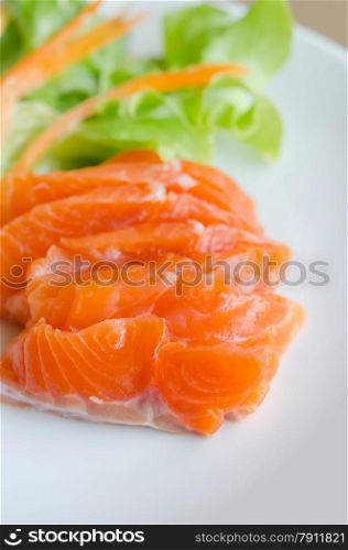 salmon sashimi with fresh salad on white dish. Salmon sashimi