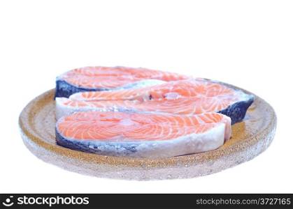 Salmon slices on a plate for cooking.