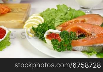 Salmon Steak And Red Caviar, In the background female is cut a piece of fish Dolly Shot Closeup