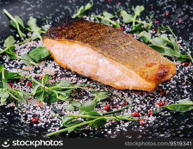 Salmon steak roasted on black plate