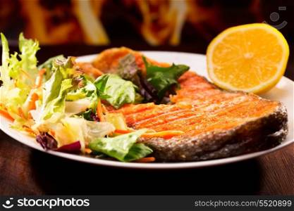 salmon steak with salad and lemon