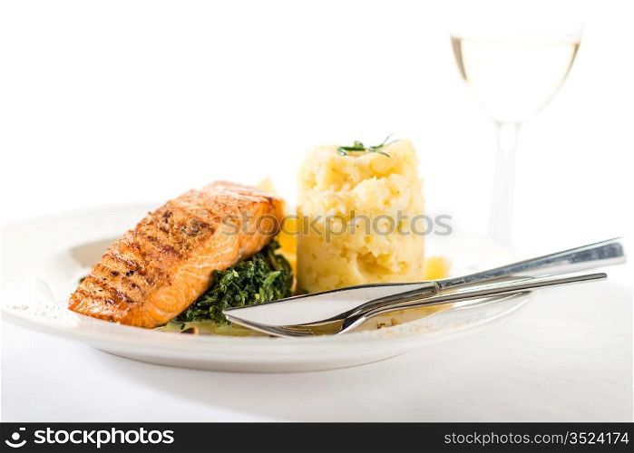 Salmon steak with spinach and mashed potatoes isolated on white