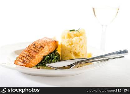 Salmon steak with spinach and mashed potatoes isolated on white