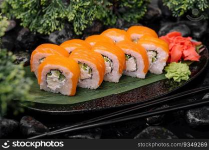 Salmon sushi with rice on black plate