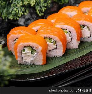 Salmon sushi with rice on black plate
