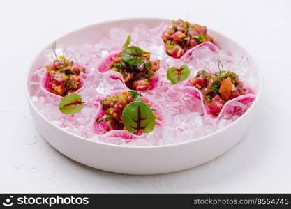 Salmon tartar in a white bowl with ice