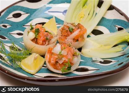 Salmon tartar in onion cups with season vegetables