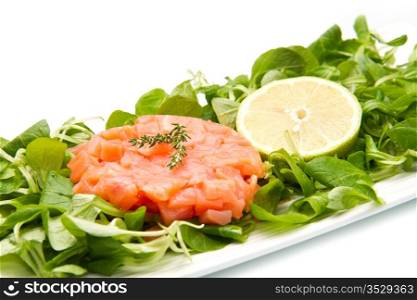 salmon tartare with fresh salad and lemon slice