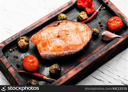 Salmon with vegetable cooking on grill.Fish steak with vegetable garnish. Fish food. Baked salmon steak