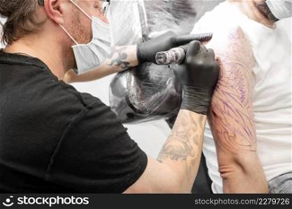 Salon tattoo. Close up of a Tattoo artist working. Tattoo artist make tattoo at the studio. High quality photography.. Salon tattoo. Close up of a Tattoo artist working. Tattoo artist make tattoo at the studio.