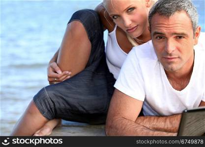 salt-and-pepper guy with laptop posing with younger girlfriend